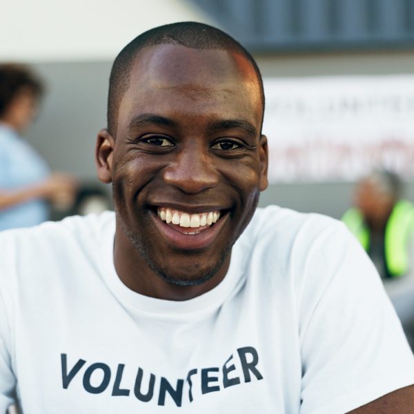 Man, volunteer and smile in portrait, charity and outreach program for society in outdoors. Happy b Man, volunteer and smile in portrait, charity and outreach program for society in outdoors. Happy b